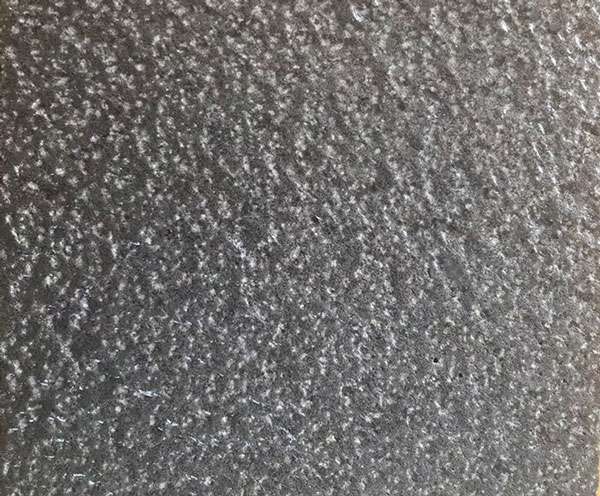 Close-up of a bush-hammered Ash Black basalt surface