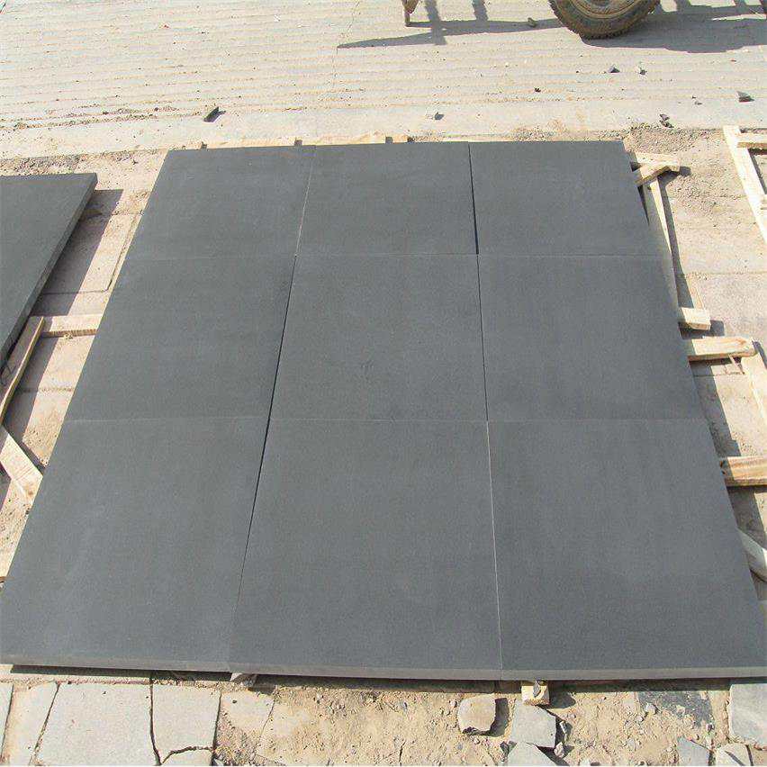 Honed Nergo Black basalt paving tiles dry-laid for inspection