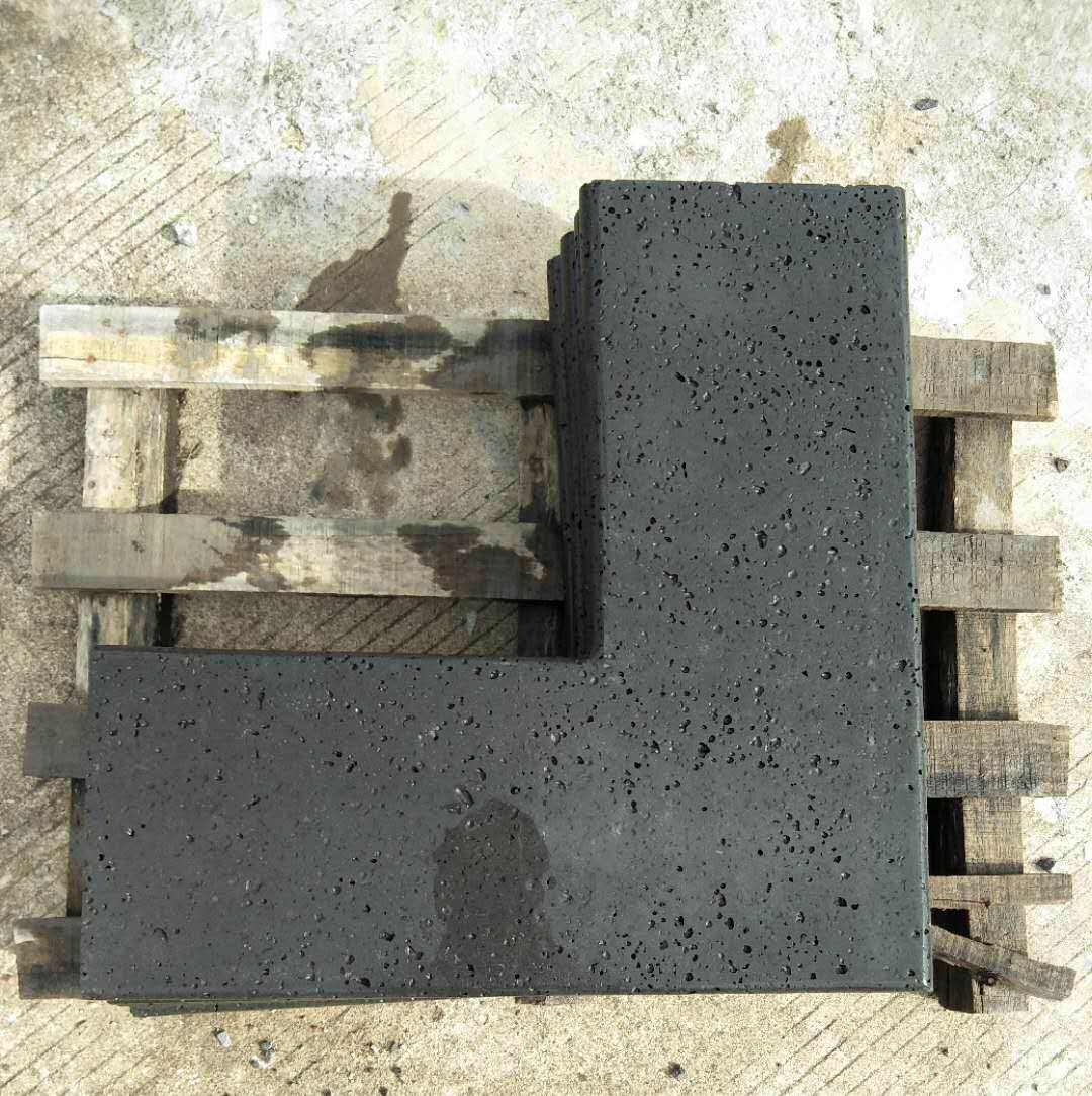 L-shaped black lava stone corner coping on a pallet