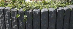 Row of split-face basalt palisades edging a planted bed