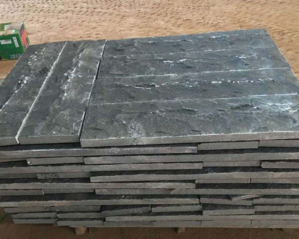 Natural split Ash Black basalt tiles stacked at the factory