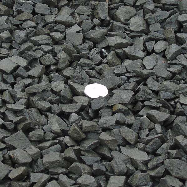 Black basalt gravel with a coin for size reference