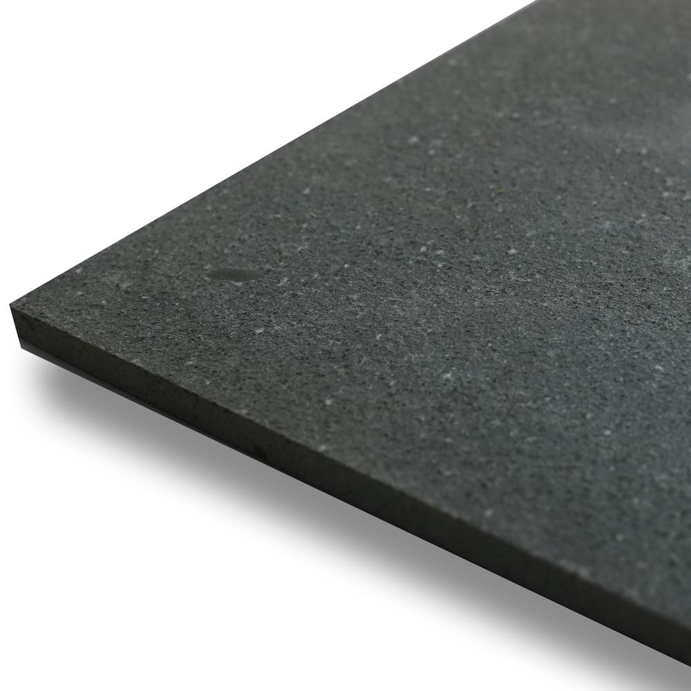 Honed black basalt tile edge showing the fine-grain surface