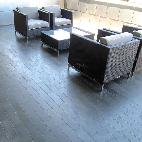 Dark basalt plank tiles on a hotel lounge floor