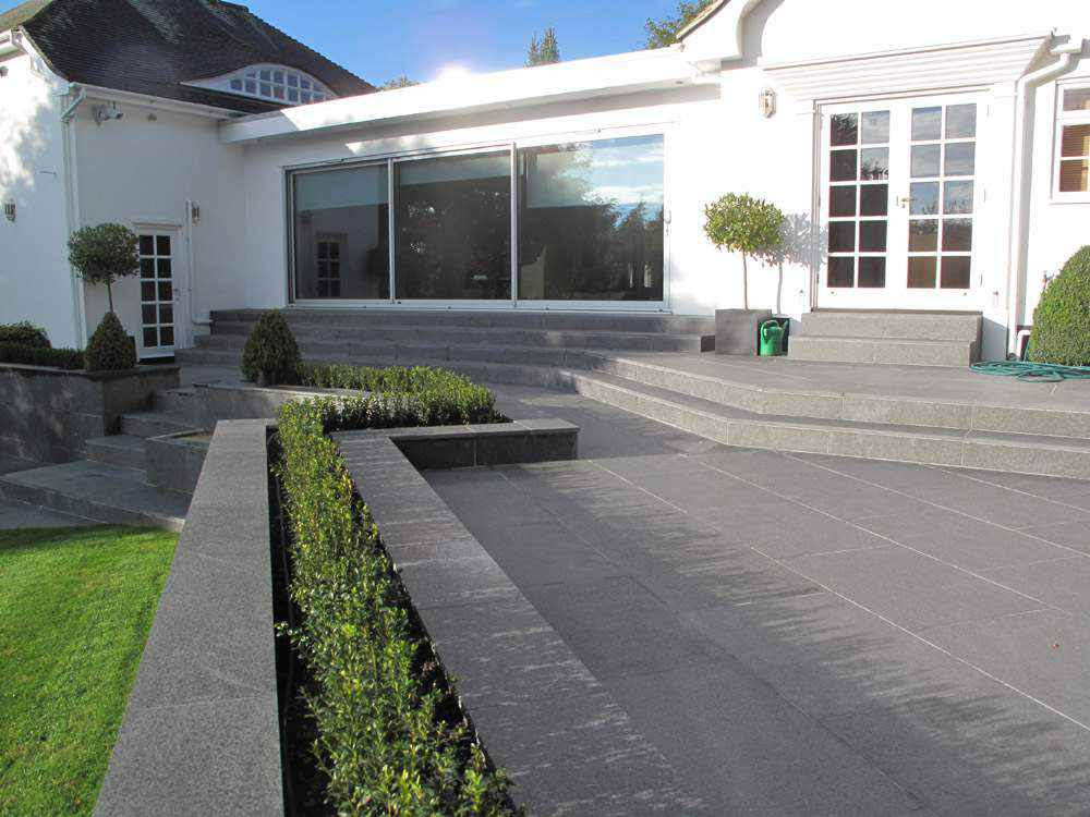 Large-format black basalt pavers on a house terrace and steps