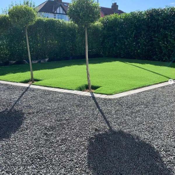 Black basalt gravel surrounding a square lawn in a formal garden
