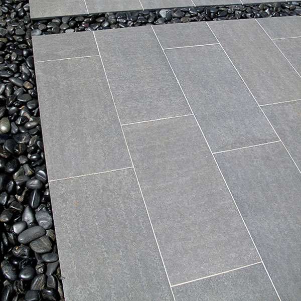 Rectangular basalt paving tiles edged with black pebbles