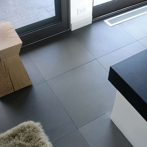 Large-format honed black basalt floor tiles in a modern interior