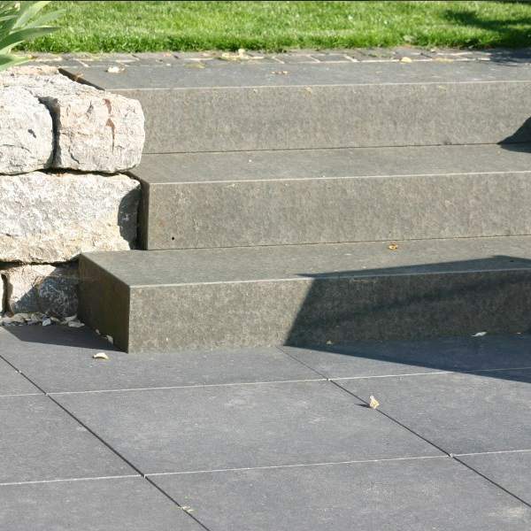 Wide black basalt steps between rough granite block walls