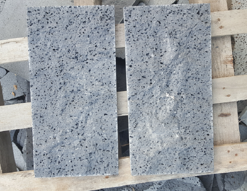 Two grey lava stone tiles showing pore pattern variation