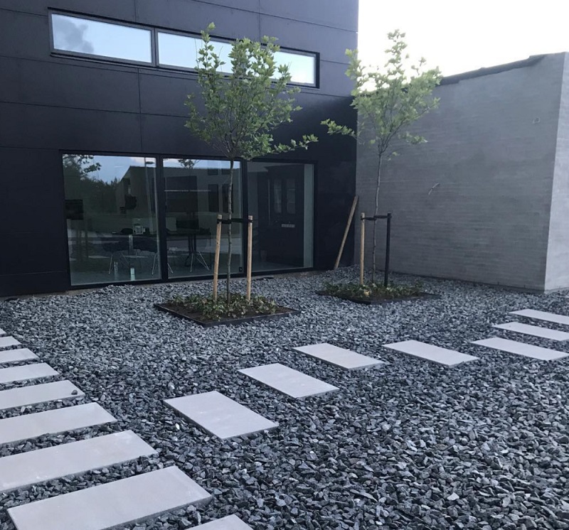 Modern home courtyard with black gravel and stepping slabs
